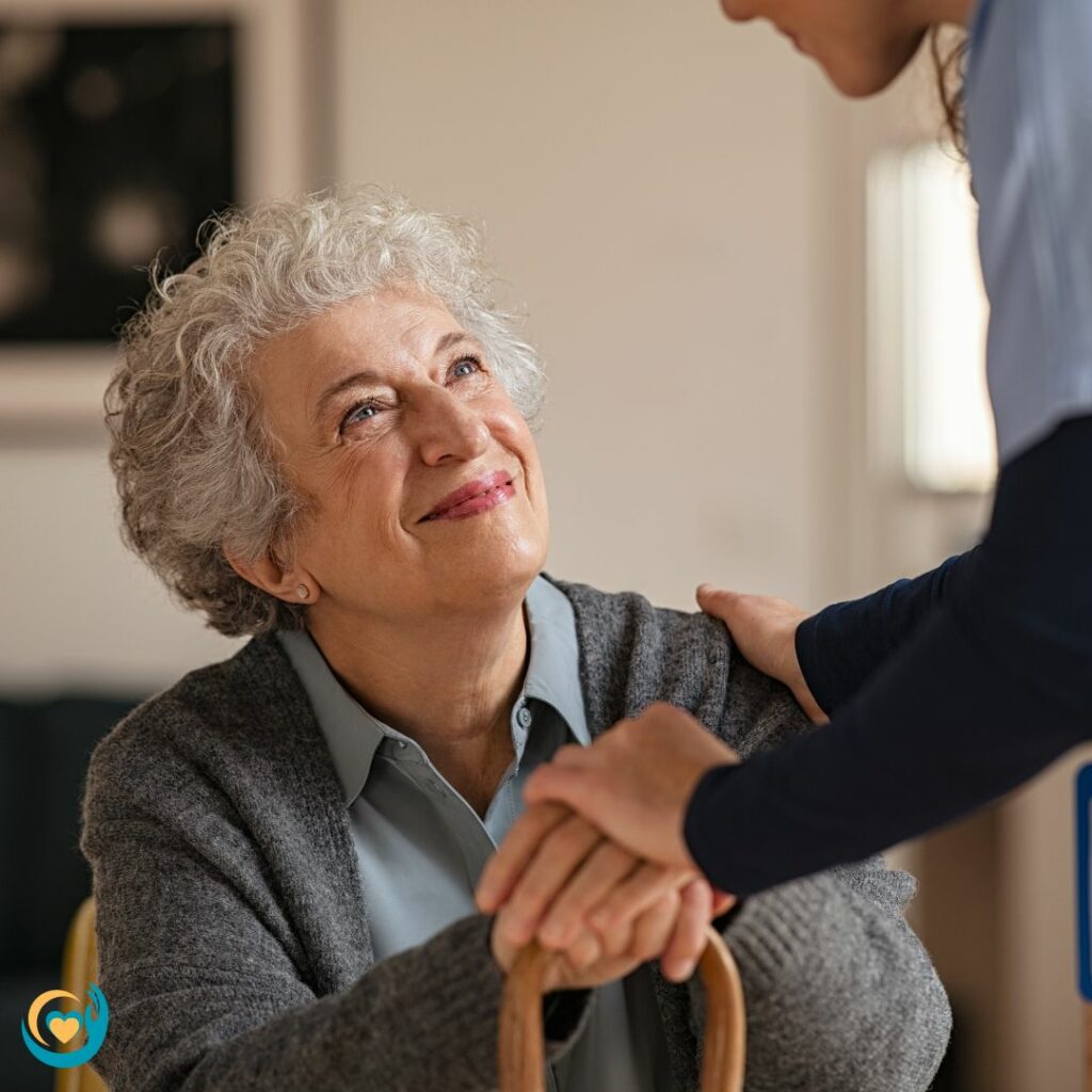 Pflegekraft hilft Seniorin beim Aufstehen aus dem Sessel | Paul Pflegebetreuung Steiermark, Burgenland, Wien, Niederösterreich